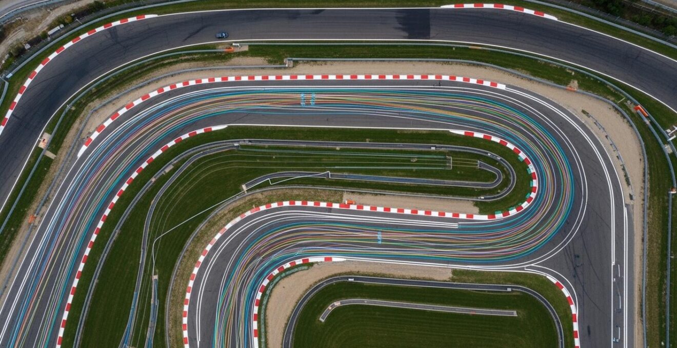 Piste automobile montrant différentes trajectoires en fonction des conditions météo et de la dégradation des pneus
